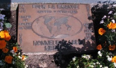 Plaque posée dans le petit massif fleuri au pied du monument «PO.TOE.AFN. Légion - Pour la France, Troupes d'Outre Mer, venus du monde entier, hors de leur sol natal, Honneur à leur Mémoire»